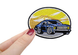 Frauenhand hält den Auto im Sonnenuntergang Patch 