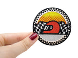 Frauenhand hält den Helm Patch