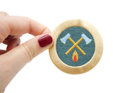 Frauenhand hält den Axt und Feuer Patch