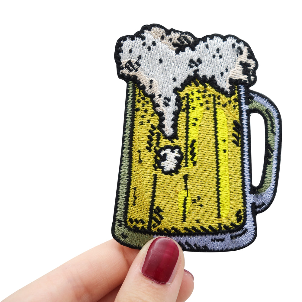 Frauenhand hält den Bier Krug Patch