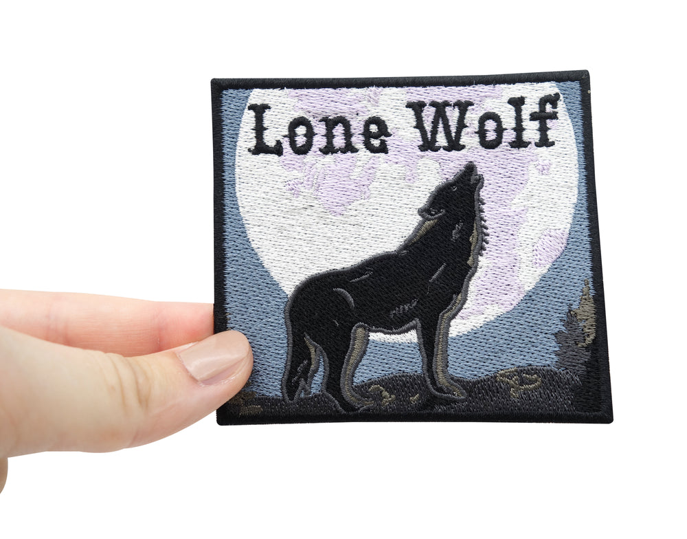 Frauenhand hält den Lone Wolf Patch