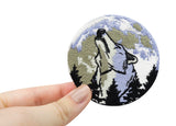 Frauenhand hält den Wolf im Vollmond Patch