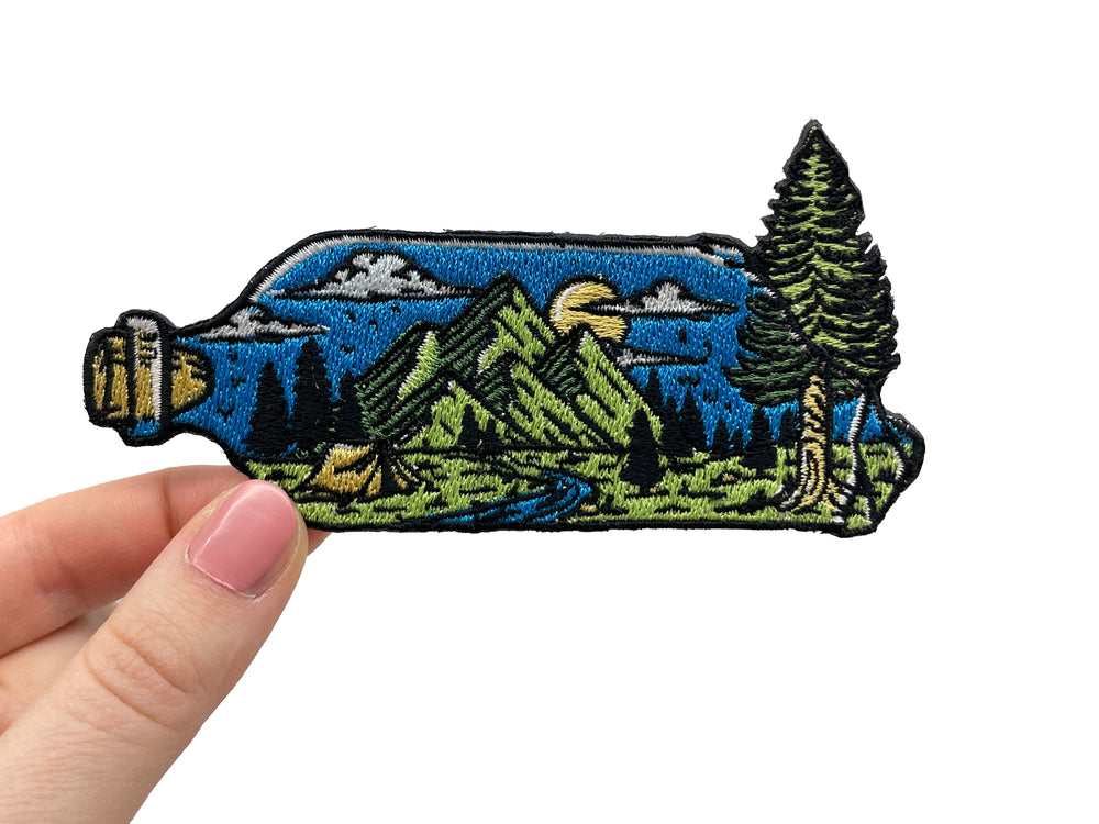 Frauenhand hält den Landschaft in Flasche Patch