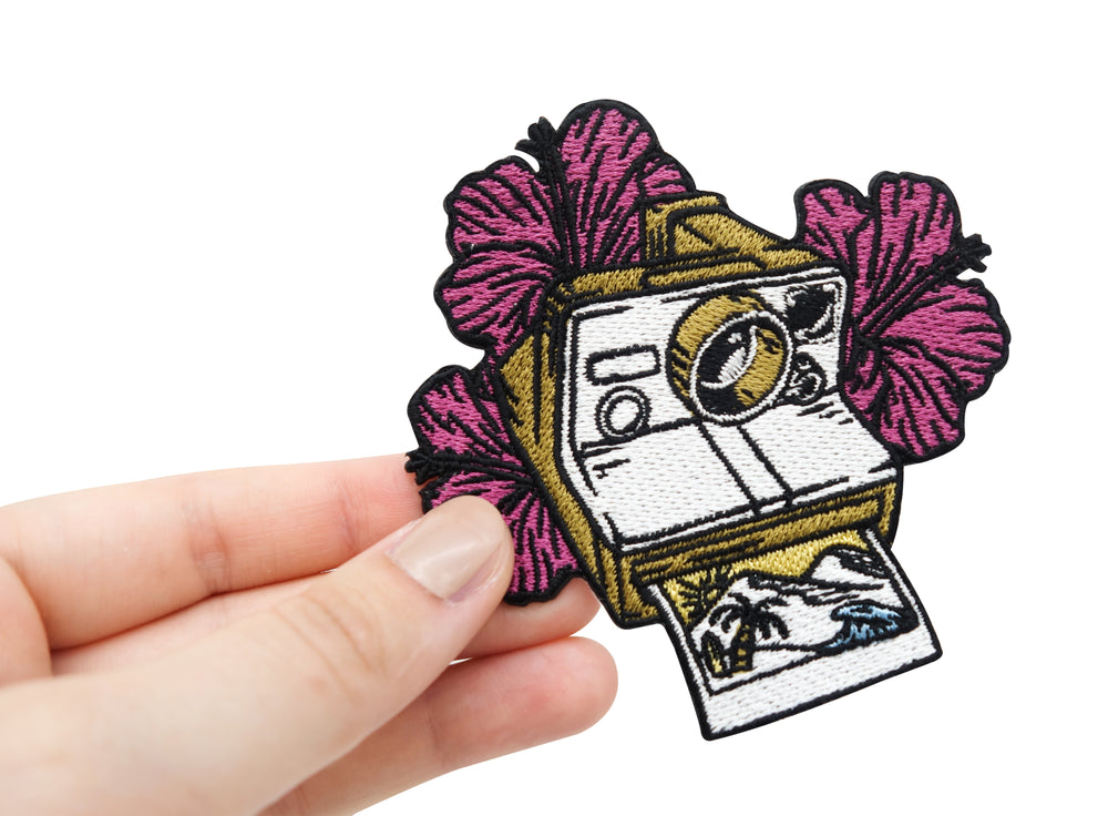 Frauenhand hält den Polaroid Kamera Patch 