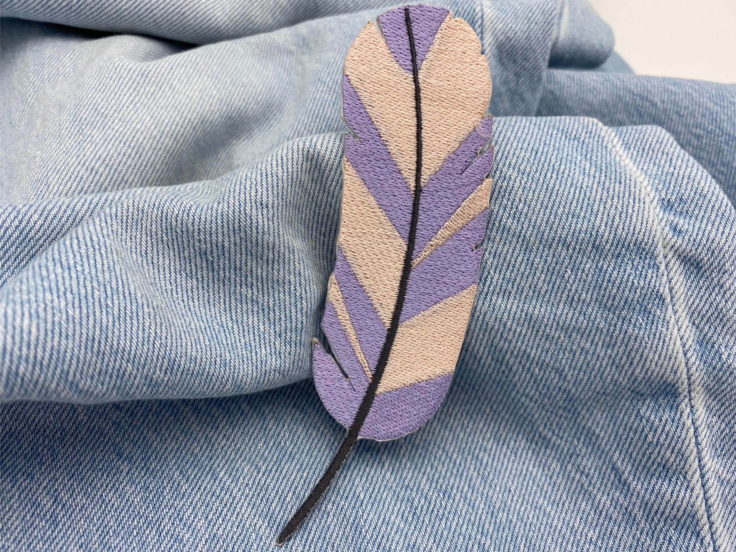 Feder Patch auf hellblauer Jeans