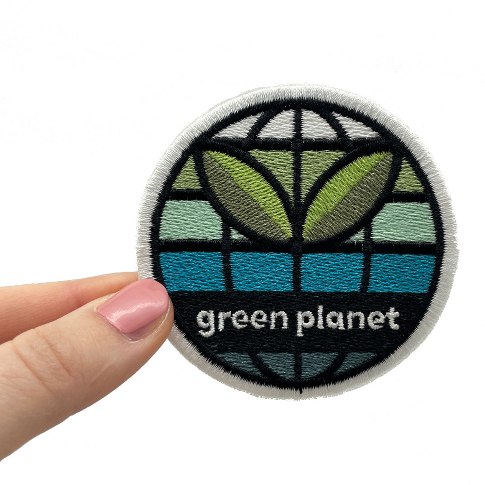 Frauenhand hält den Green Planet Patch