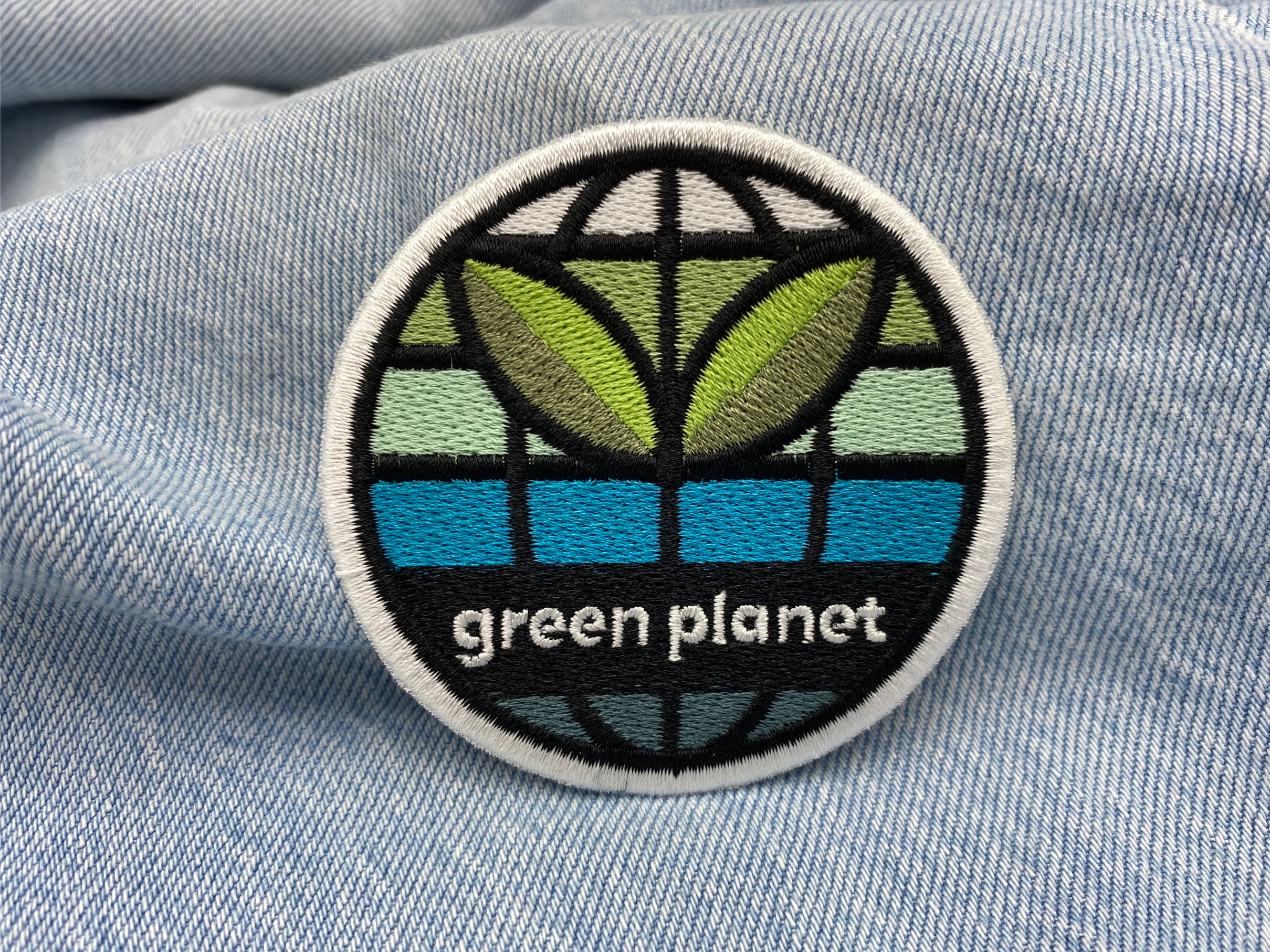 Green Planet Patch auf hellblauer Jeans