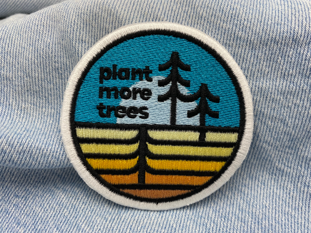Plant more Trees Patch auf hellblauer Jeans