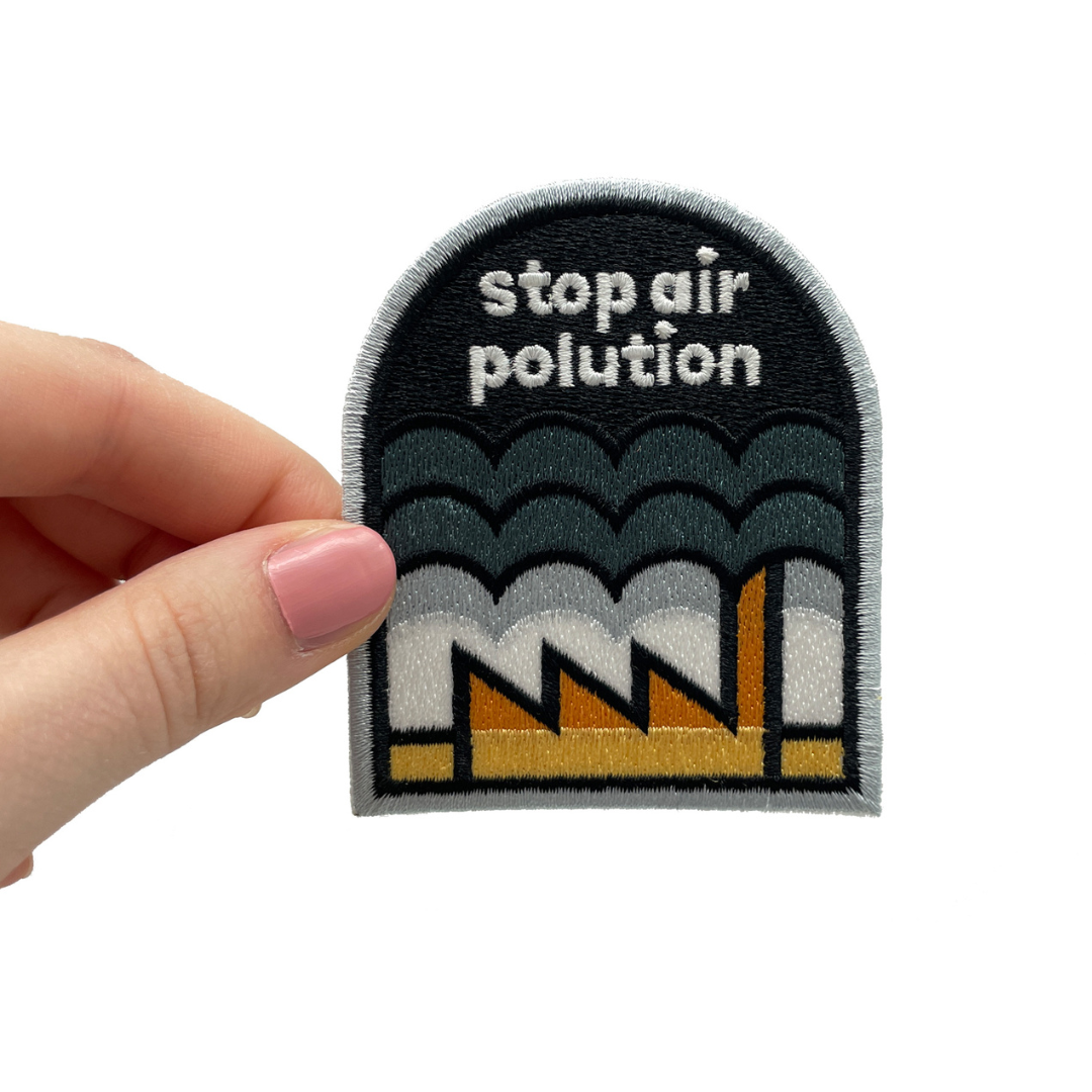 Frauenhand hält den Stop Air Polution Patch
