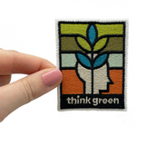 Frauenhand hält den Think Green Patch