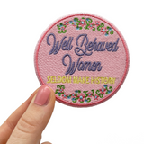 Pinker Well Behaved Women Patch gehalten von einer Frauenhand