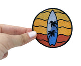 Surfbrett Patch gehalten von einer Frauenhand 