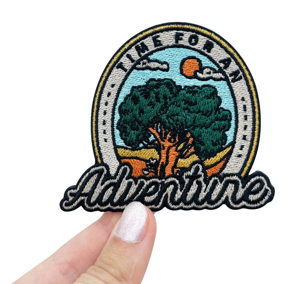 Frauenhand hält den Time for an Adventure Patch