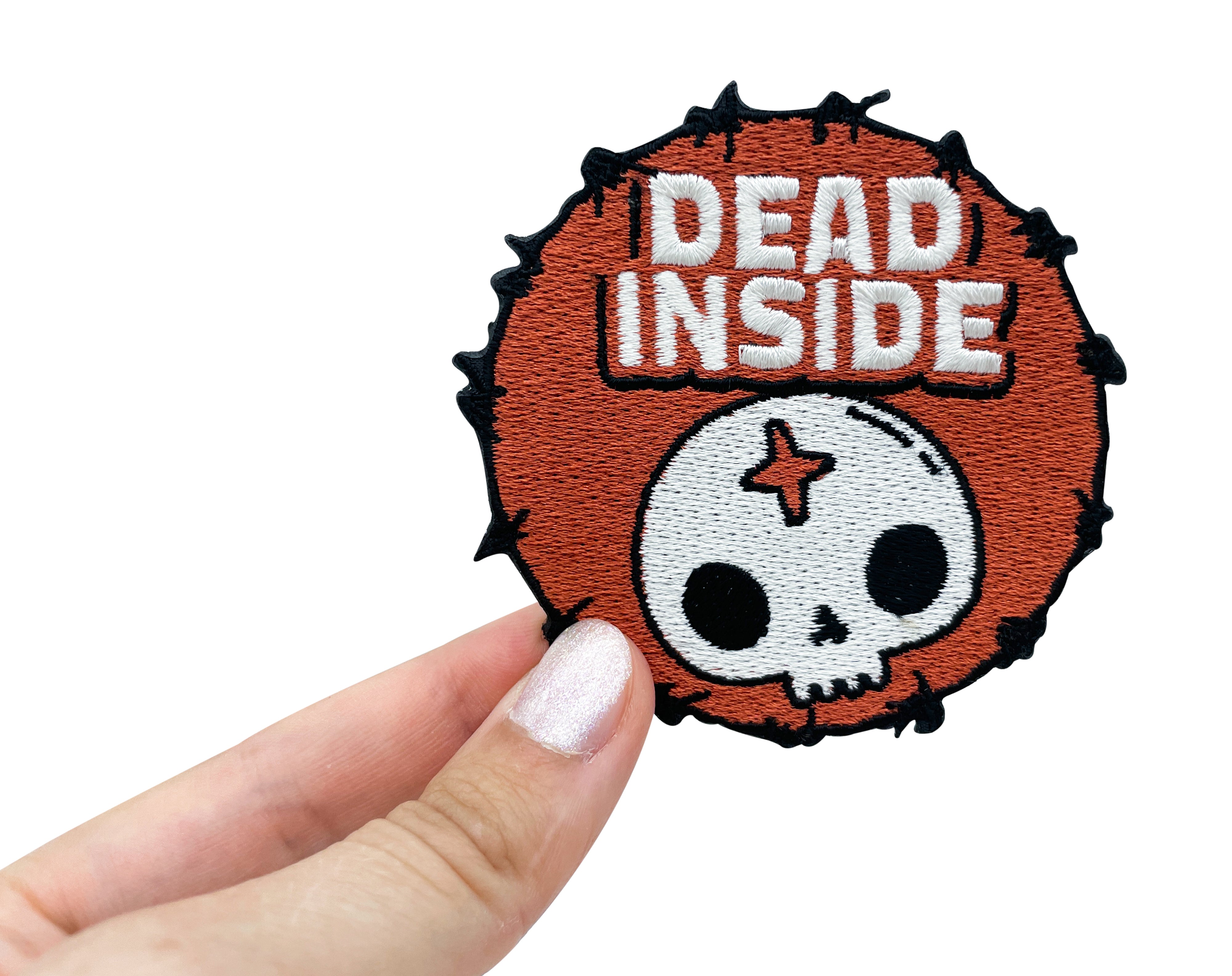 Dead Inside Patch gehalten von einer Frauenhand
