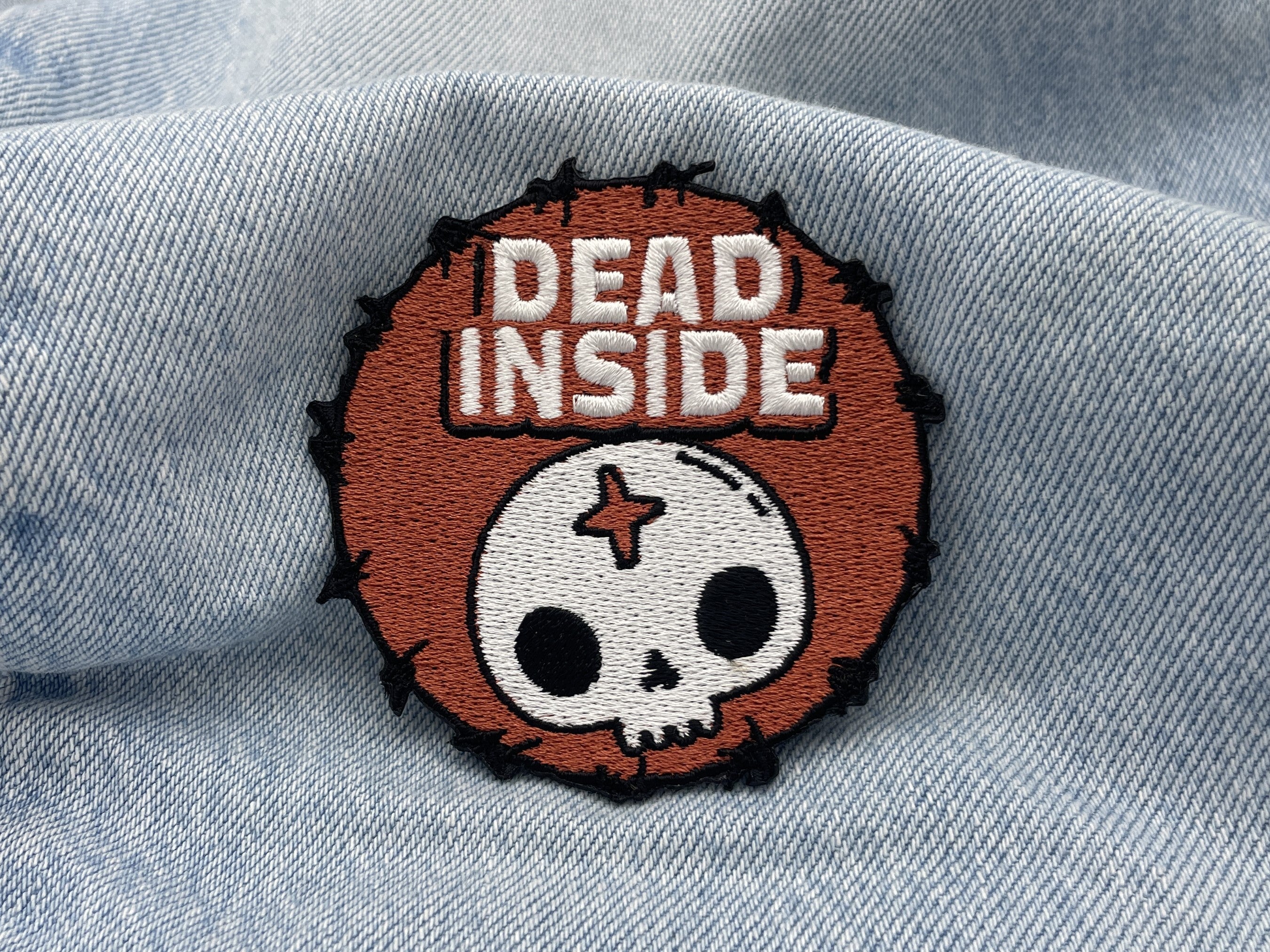 Dead Inside Patch auf hellblauer Jeans