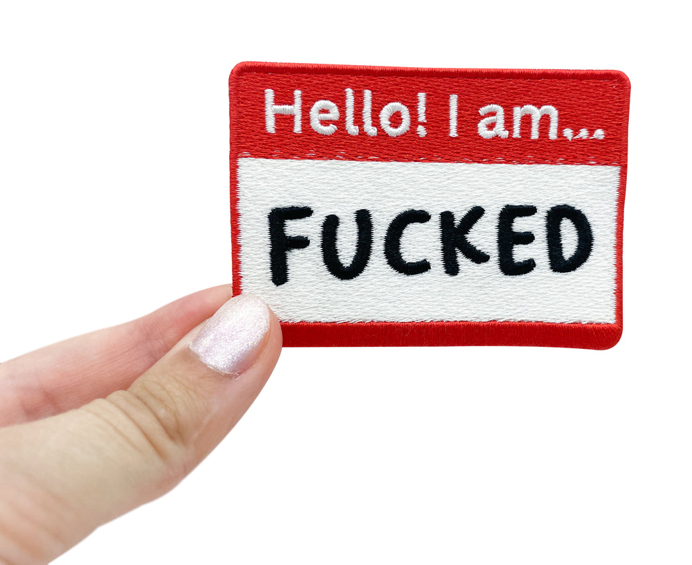 Frauenhand hält den Hello! I am F**** Patch