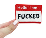 Frauenhand hält den Hello! I am F**** Patch