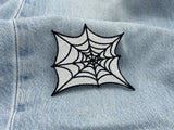 Spinnennetz Patch auf einer hellblauen Jeans