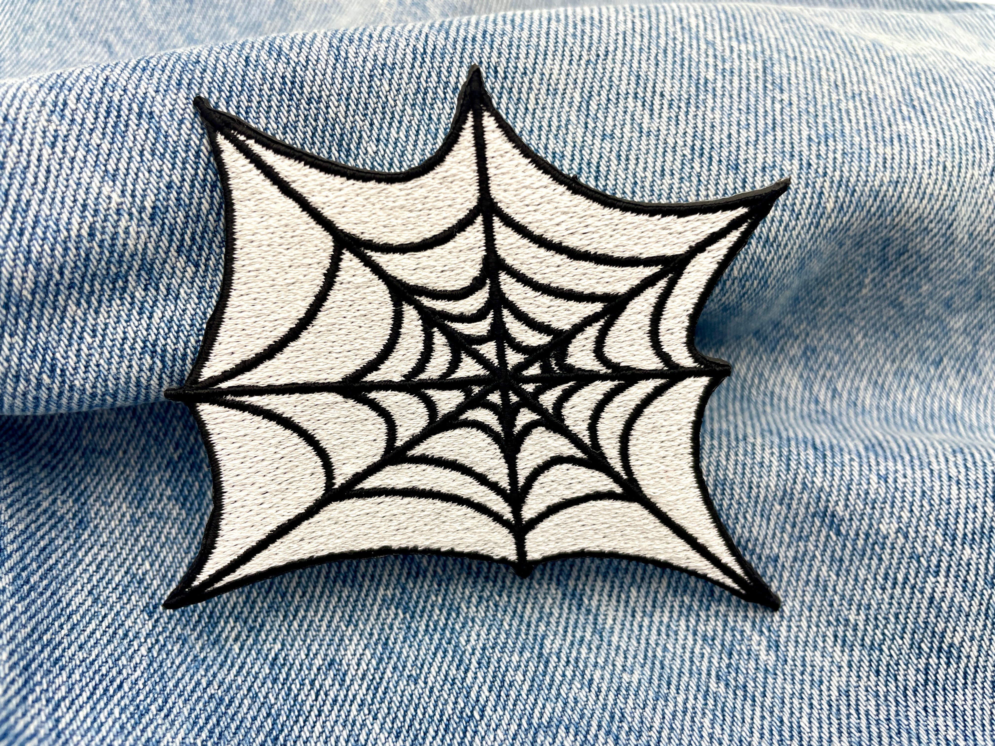 Spinnennetz Patch auf blauer Jeans