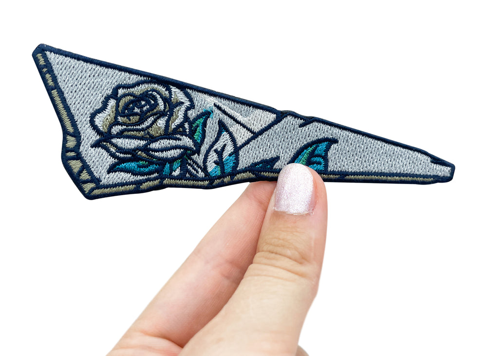 Frauenhand hält den Glasscherbe mit einer Rose Patch