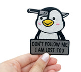 Pinguin Patch gehalten von einer Frauenhand