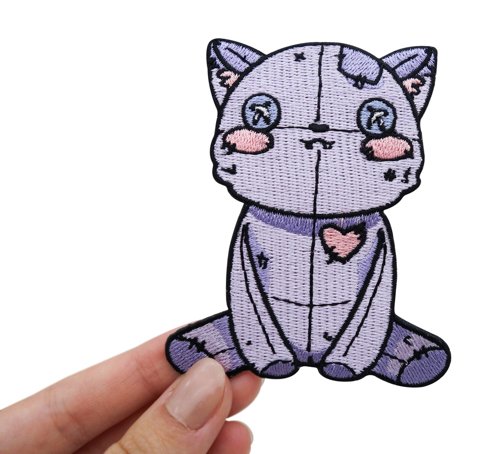 Frauenhand hält den Vodoo Katzen Patch