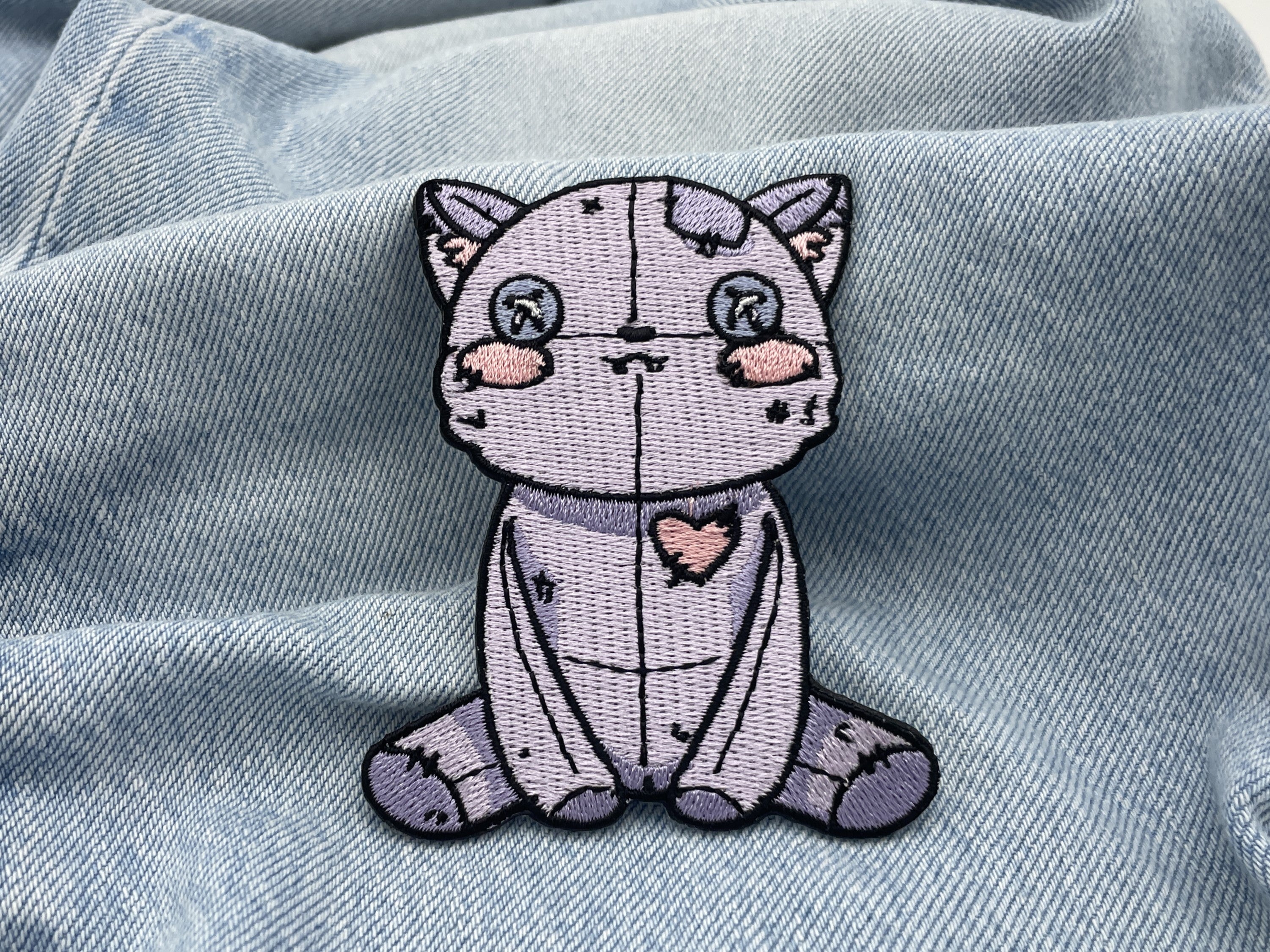 Vodoo Katze Patch auf hellblauer Jeans