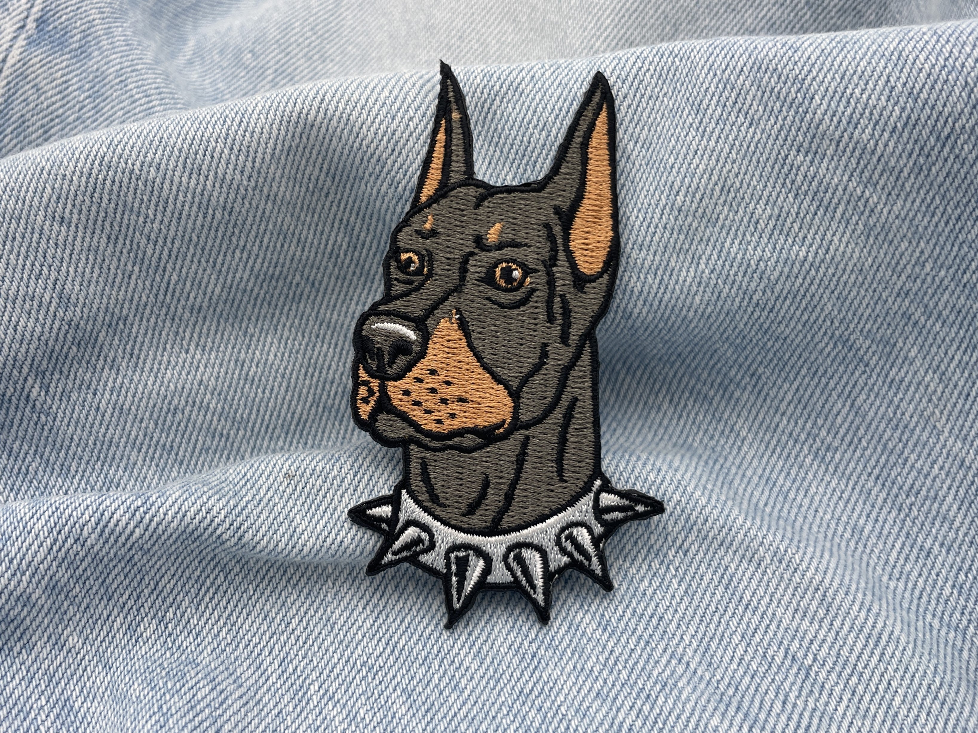 Dobermann Patch auf hellblauer Jeans