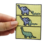 Frauenhand hält den Dino Evolution Patch