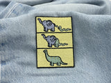 Dino Evolution Patch auf hellblauer Jeans