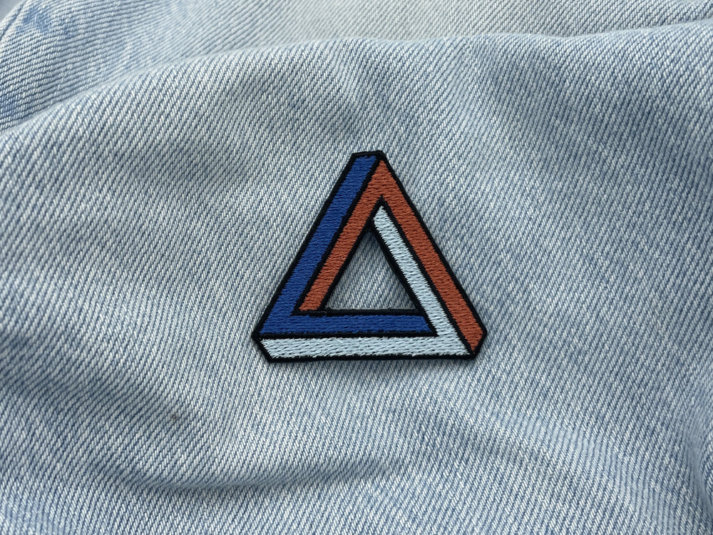Penrose Dreieck Patch auf hellblauer Jeans
