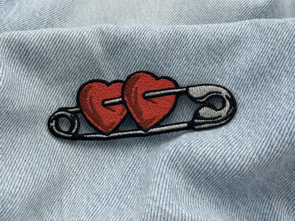 Sicherheitsnadel Patch auf hellblauer Jeans