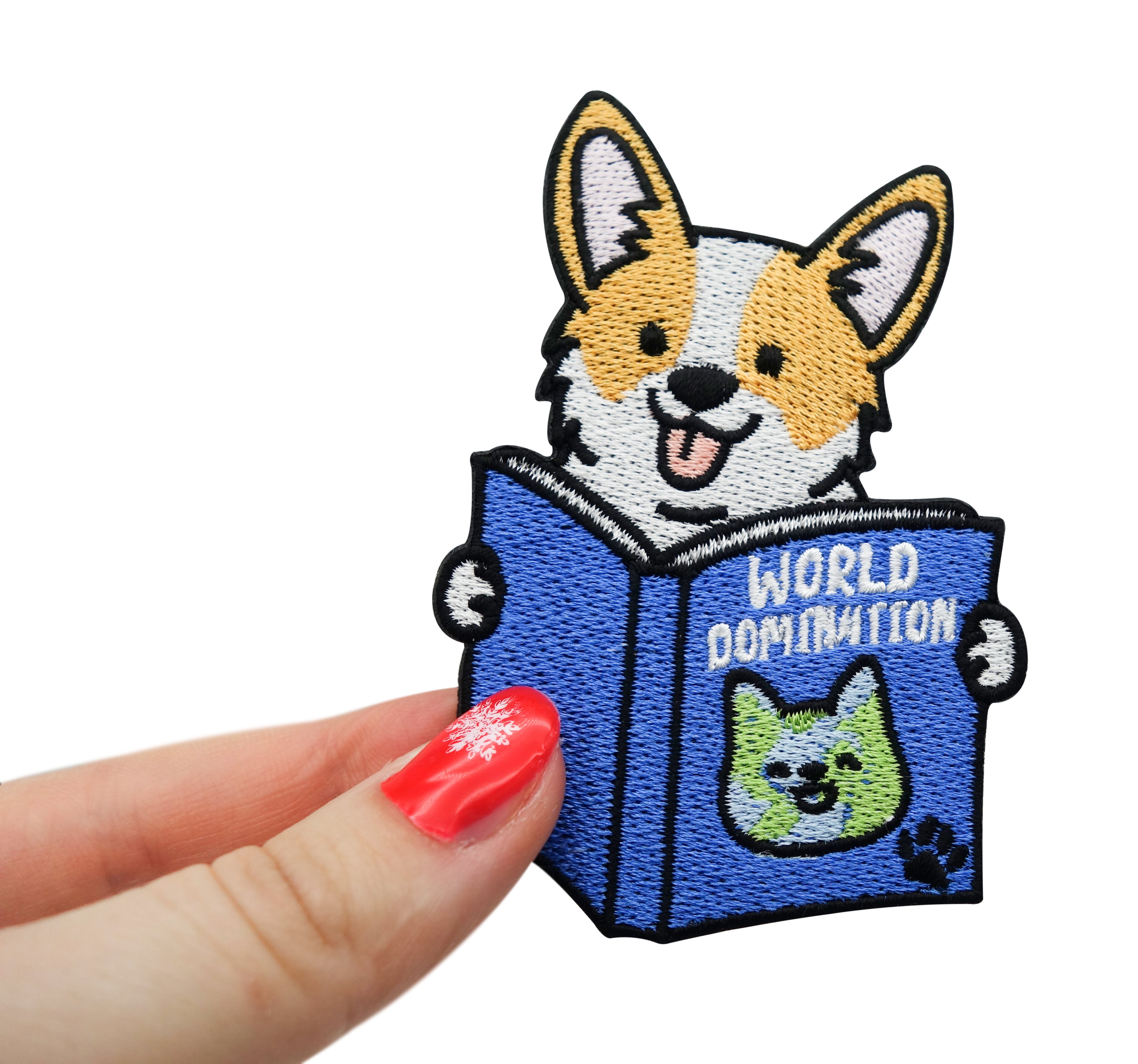 Frauenhand hält den World Domination Hund Patch