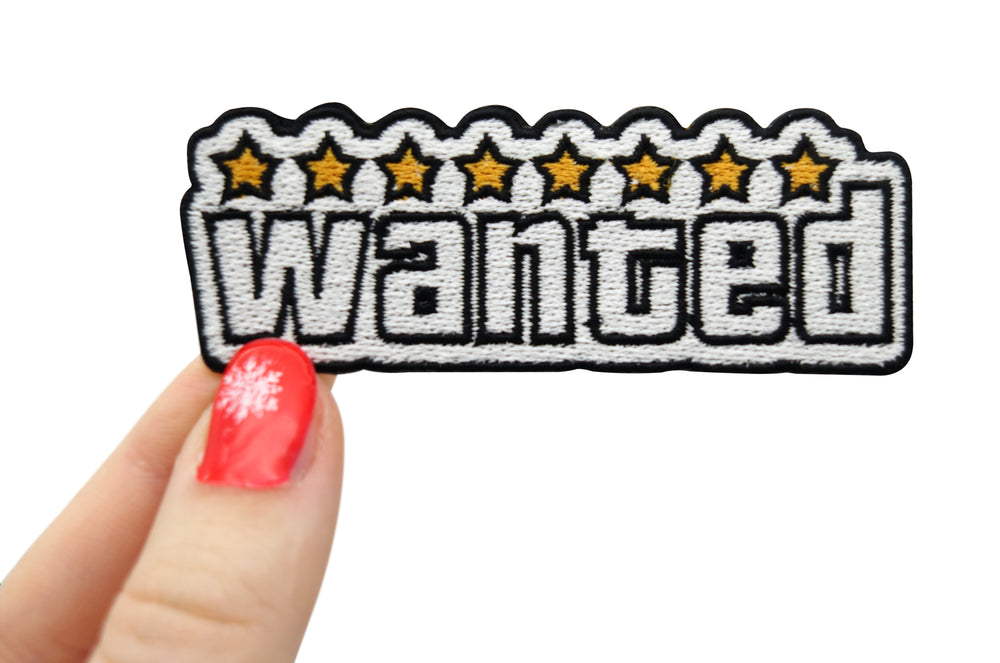 Frauenhand hält den Wanted Patch