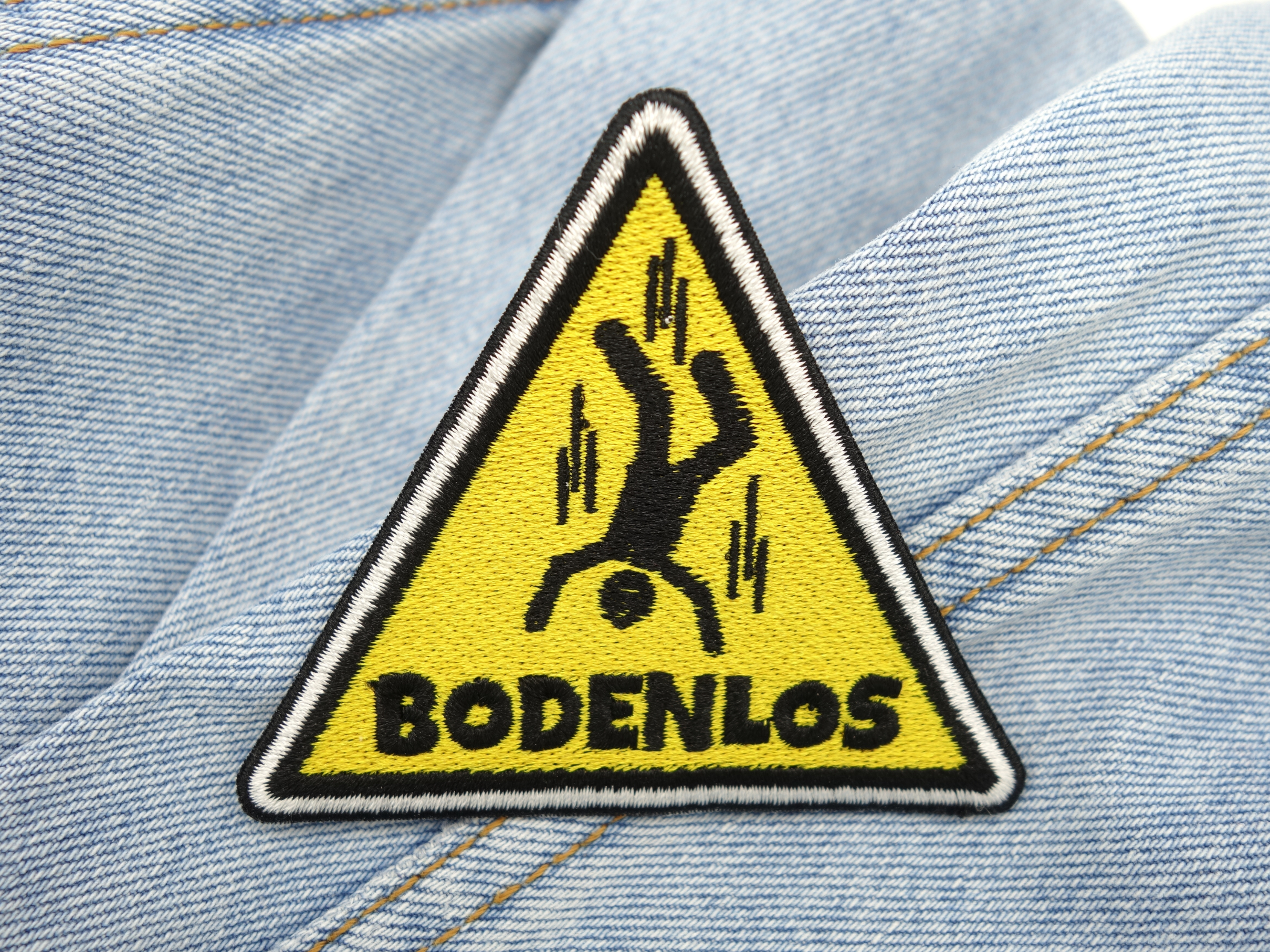 Bodenlos Warndreieck Patch auf hellblauer Jeans