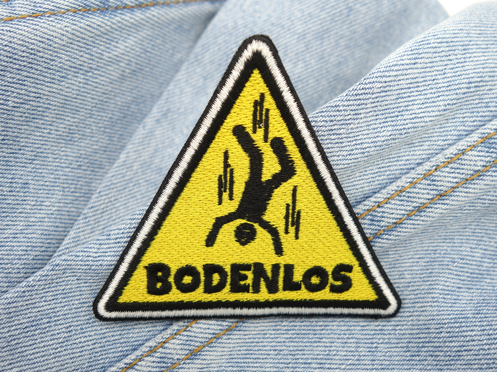 Bodenlos Warndreieck Patch auf hellblauer Jeans