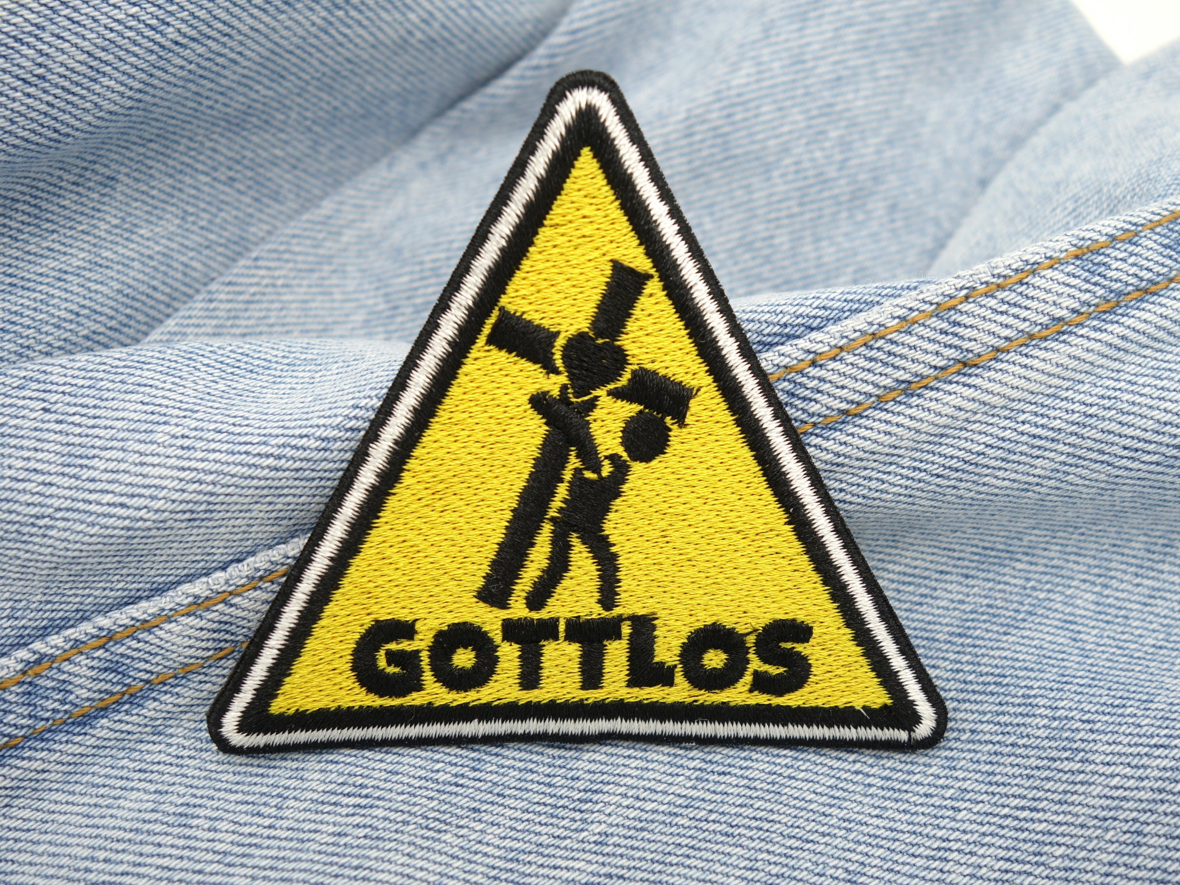 Gottlos Dreieck Patch auf hellblauer Jeans