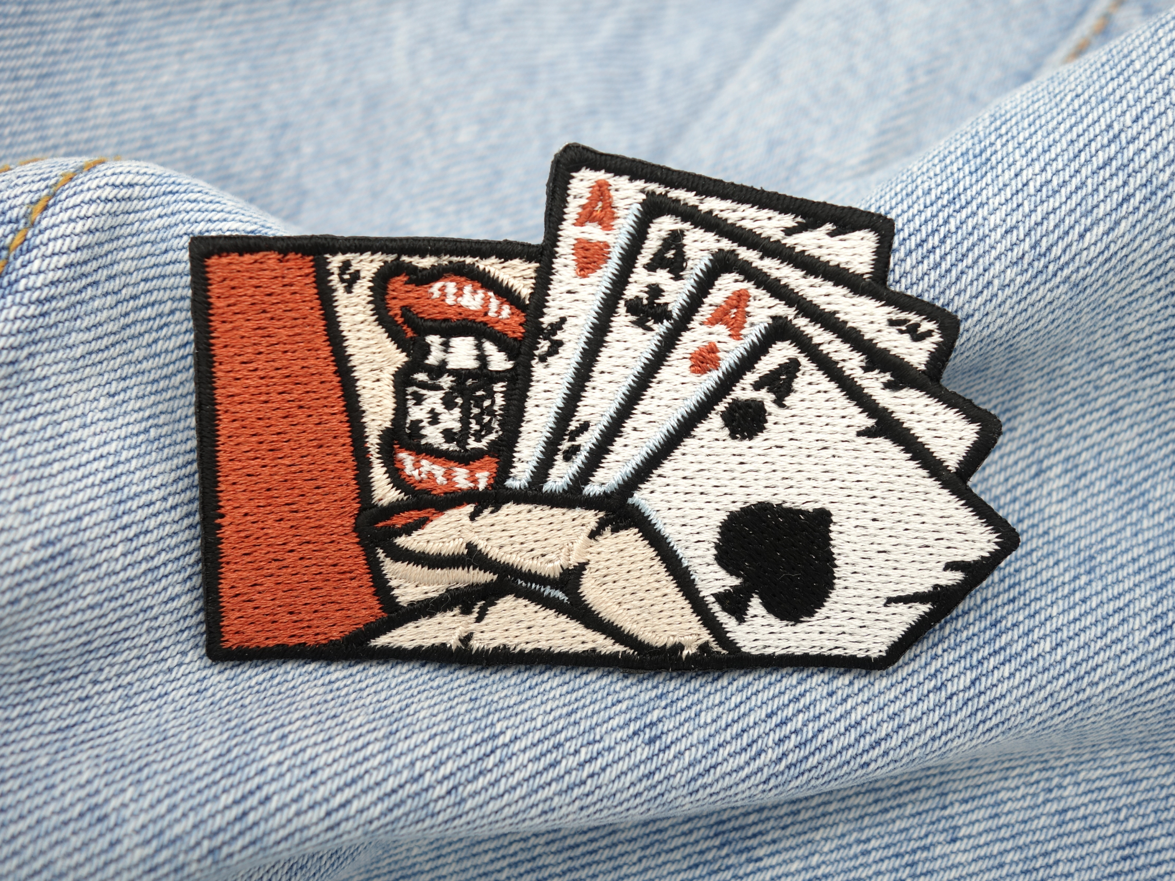 4 Asse Patch auf hellblauer Jeans