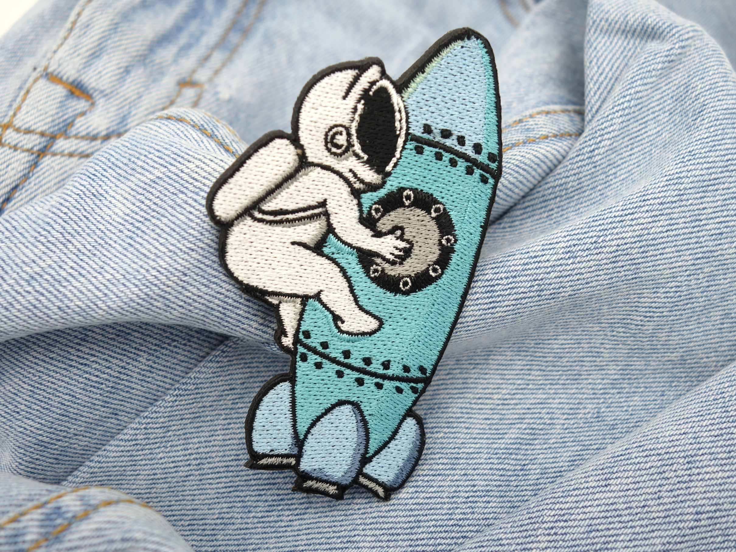 Astronaut auf Rakete Patch auf hellblauer Jeans