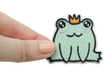 Frosch Prinz Patch gehalten von einer Frauenhand