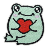 Grüner Frosch hält ein kleines Herz Patch