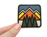 Frauenhand hält den Retro Berge Patch
