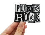 Punk Rock Patch gehalten von einer Frauenhand 