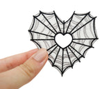 Spinnenweben Herz Patch gehalten von einer Frauenhand