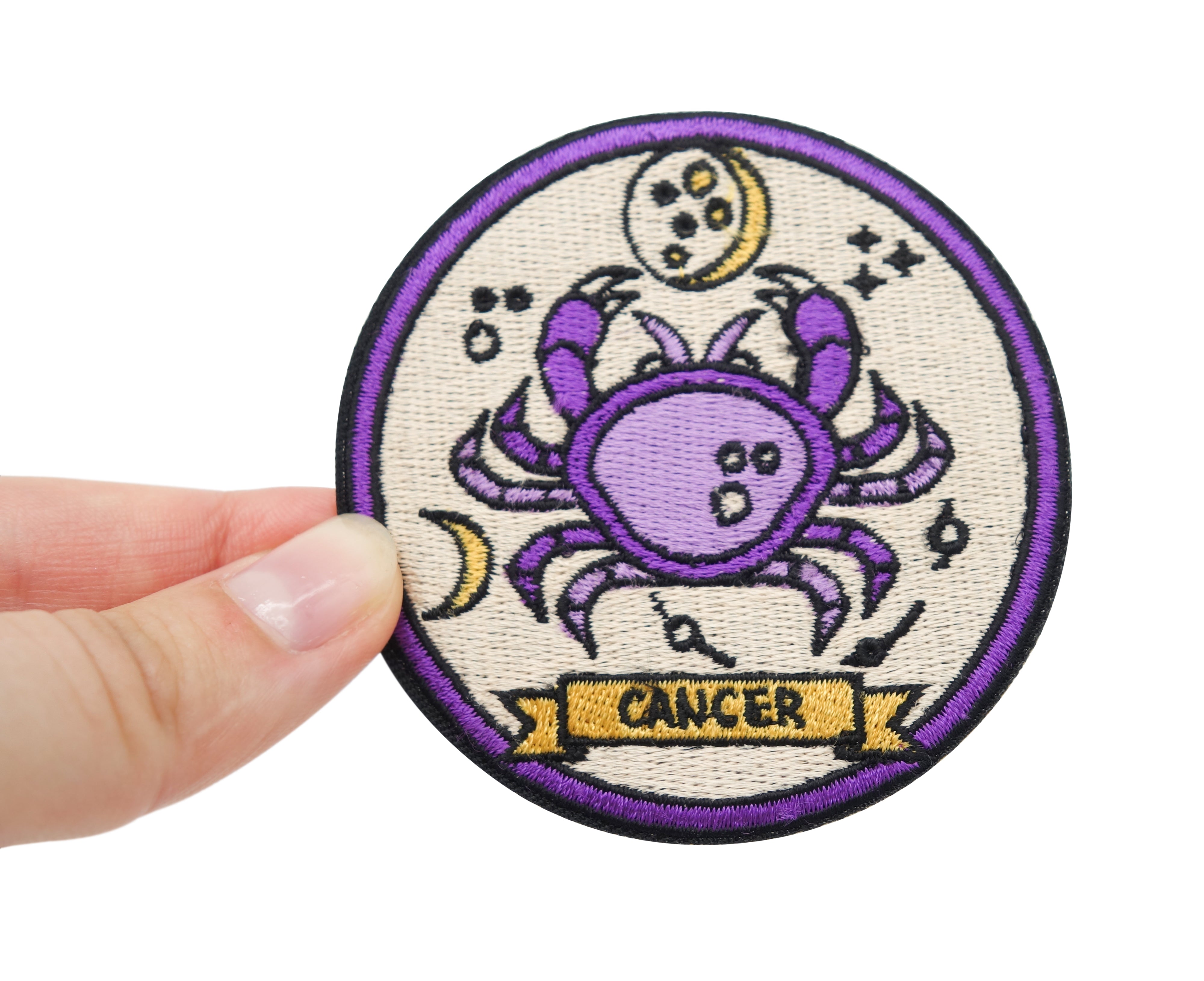 Frauenhand hält den Krebs Sternzeichen Patch