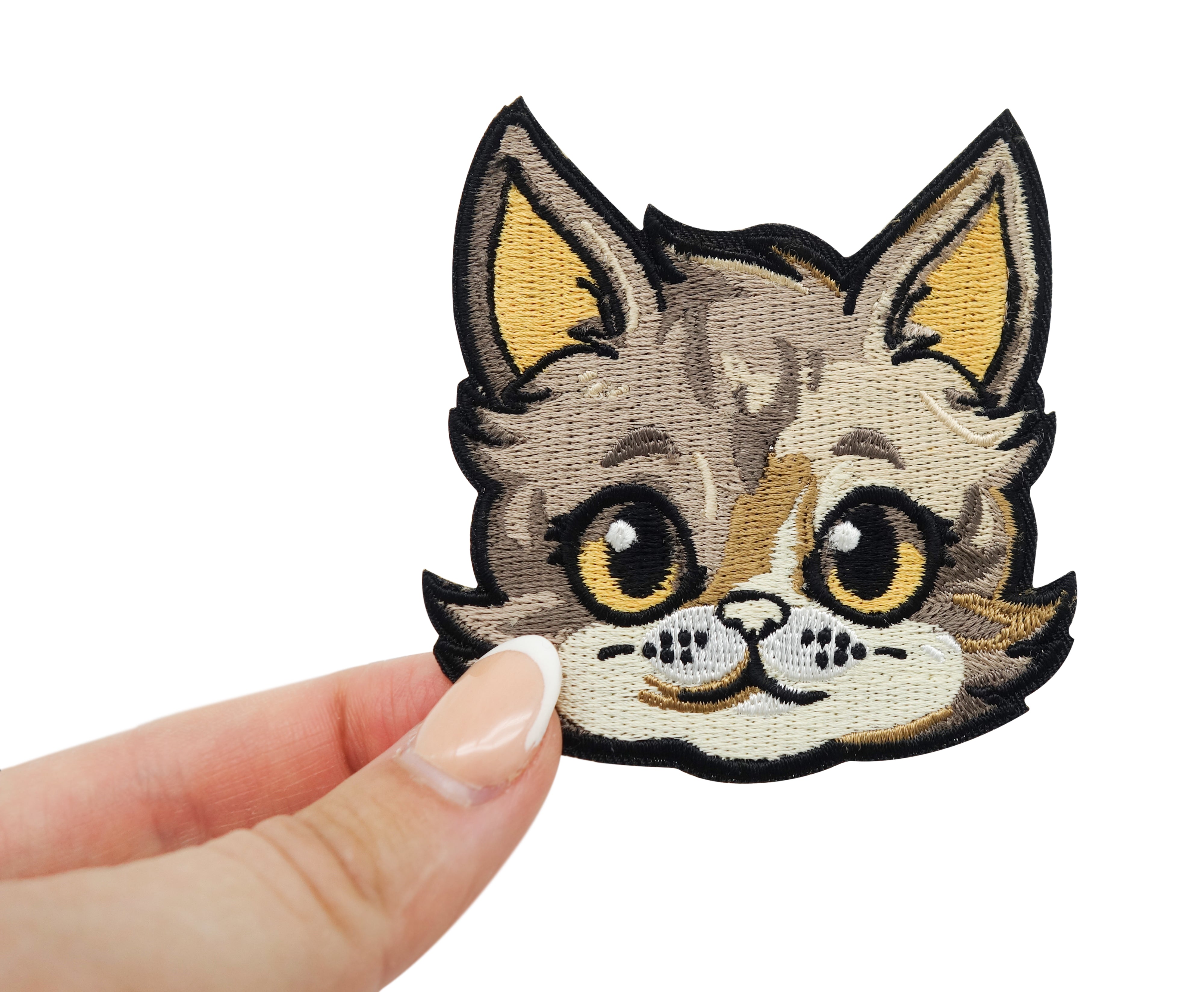 Frauenhand hält den Katzenkopf Patch