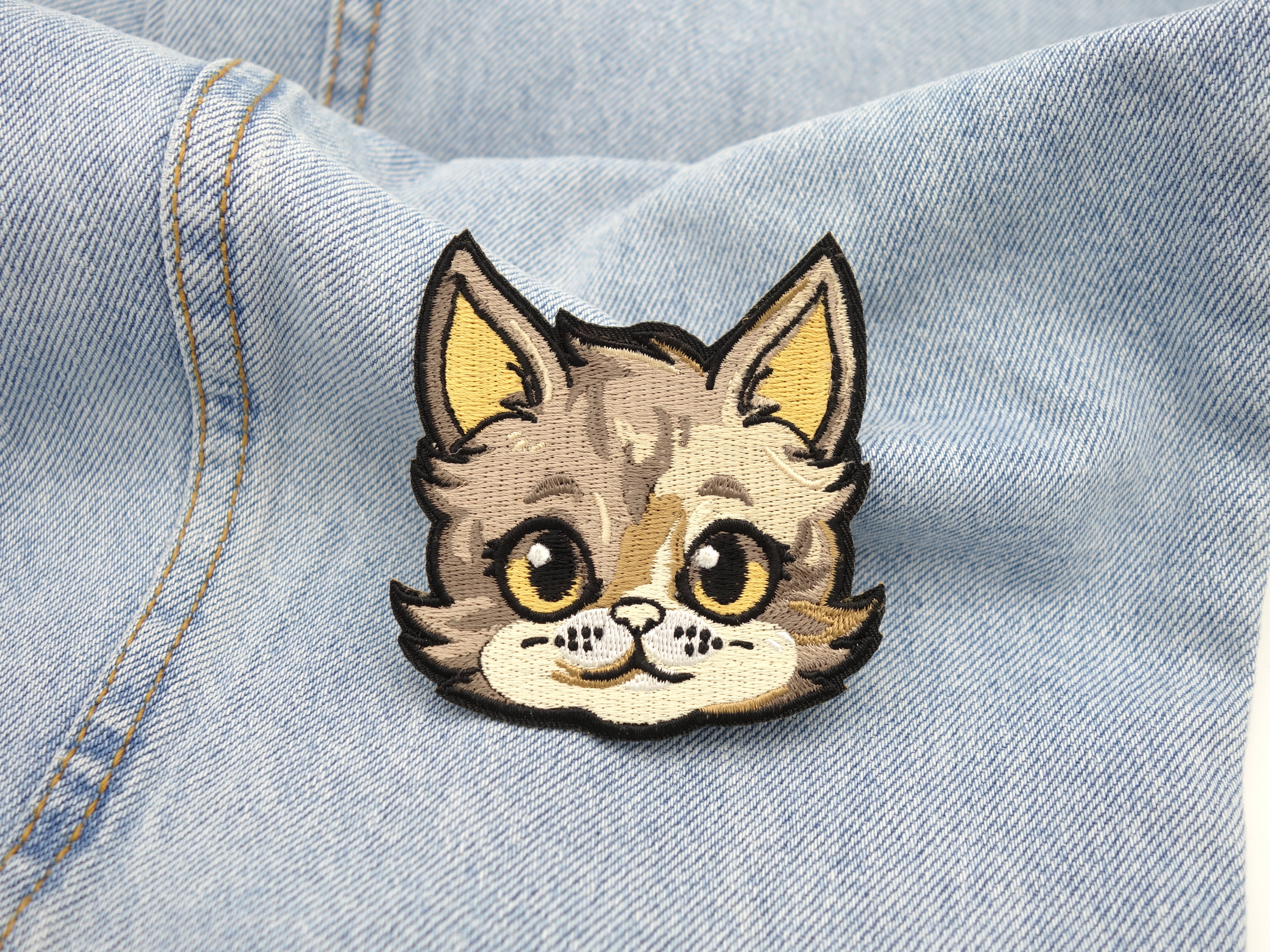 Katzenkopf Patch auf hellblauer Jeans