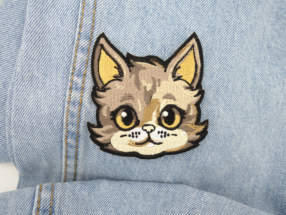 Katzenkopf Patch auf hellblauer Jeans aufgebügelt