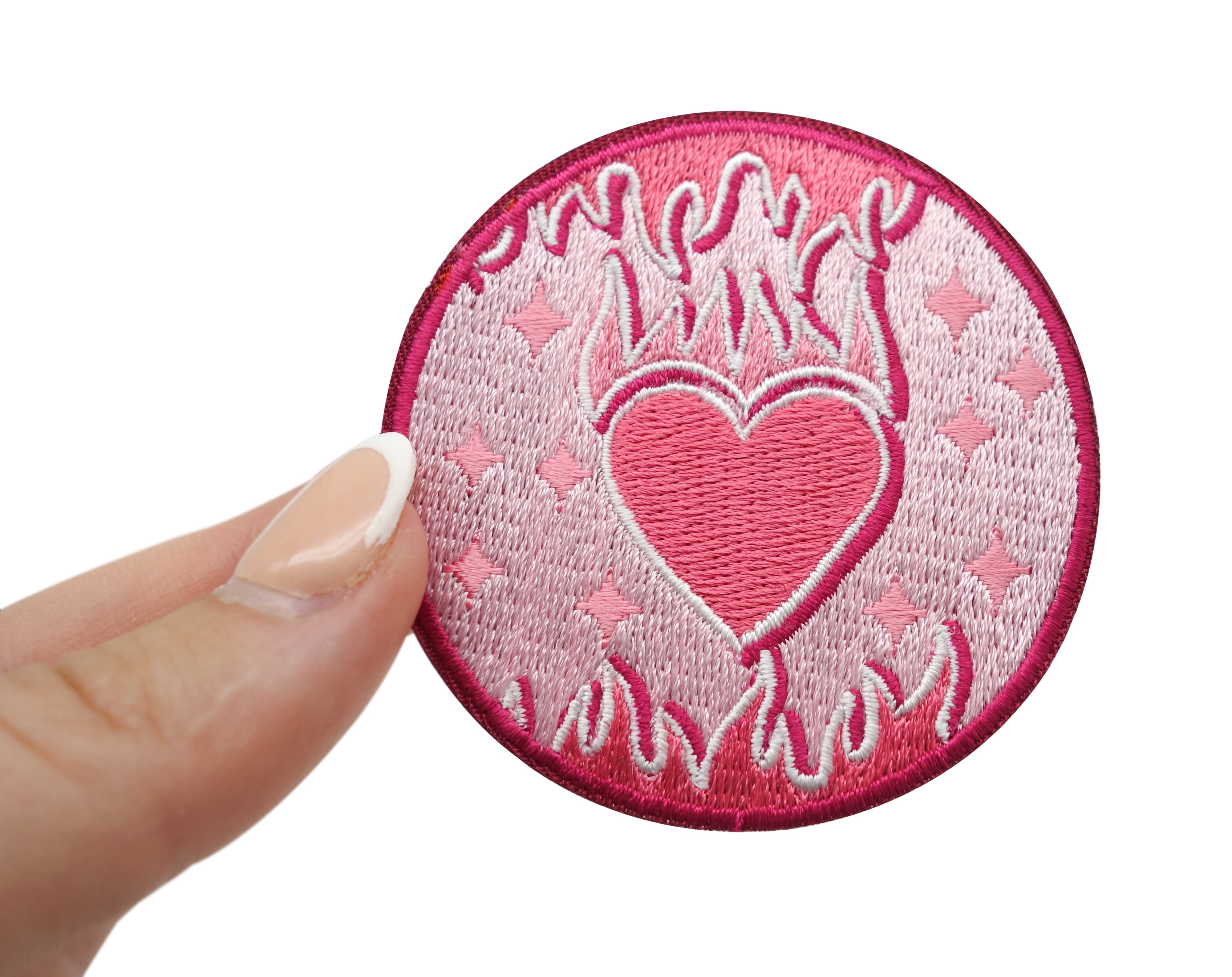 Flammendes Herz Patch gehalten von einer Frauenhand 