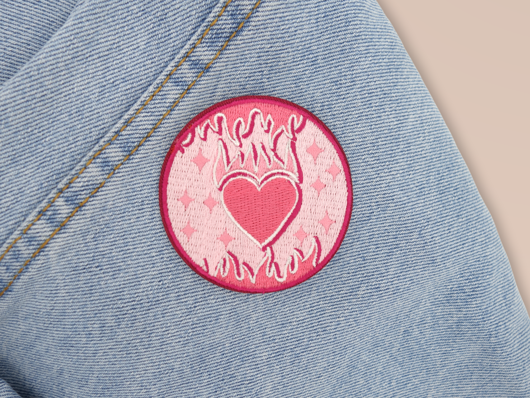 Flammendes Herz Patch auf hellblauer Jeans aufgebügelt